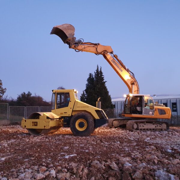 bager i valjak ravnaju tlo